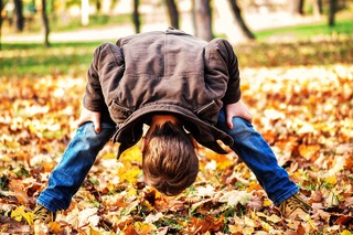 Child Playing in Autumn Leaves